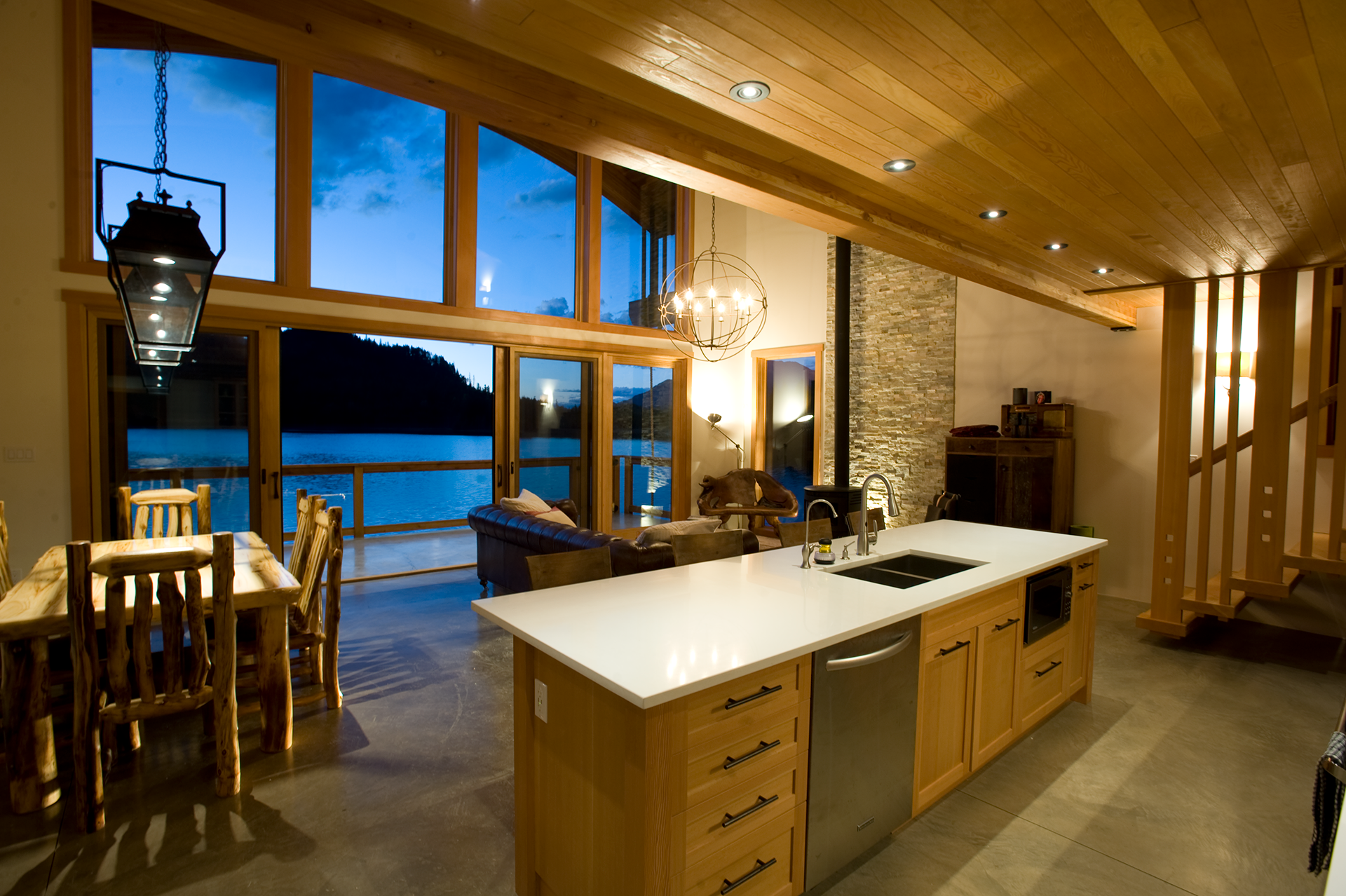 kitchen bar, dining, and living area with a view of the lake outside