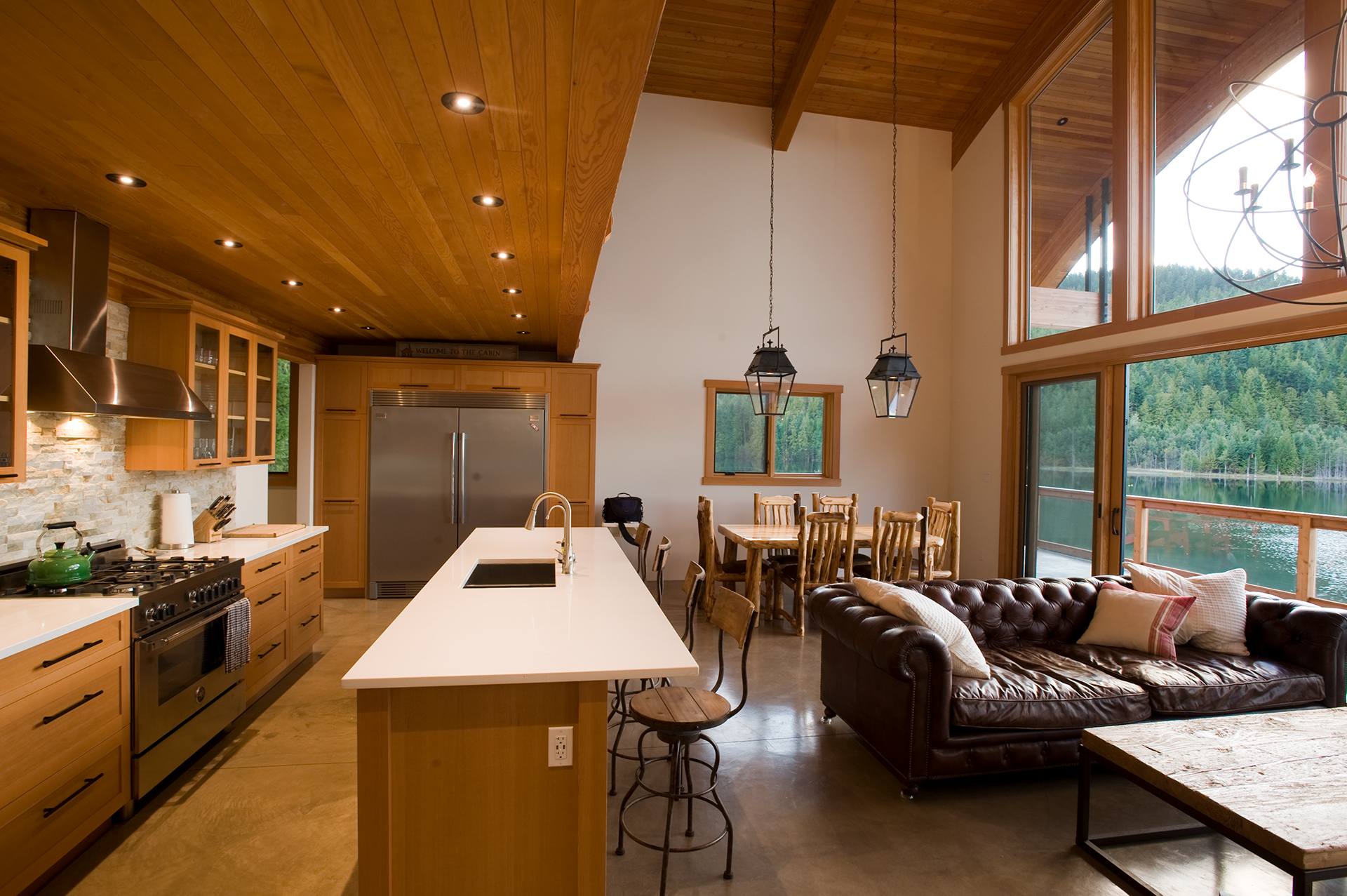 kitchen bar, dining, and living area with a view of the lake outside