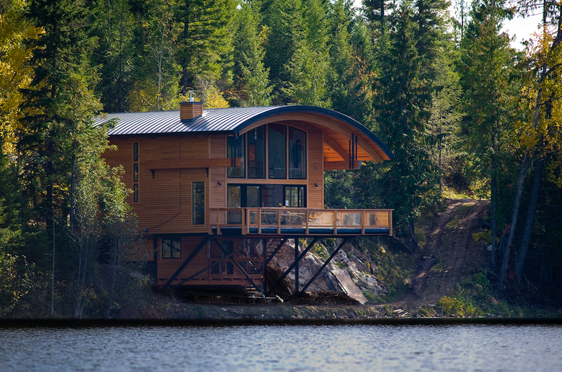 timber-enhanced lakeside house with curved roof