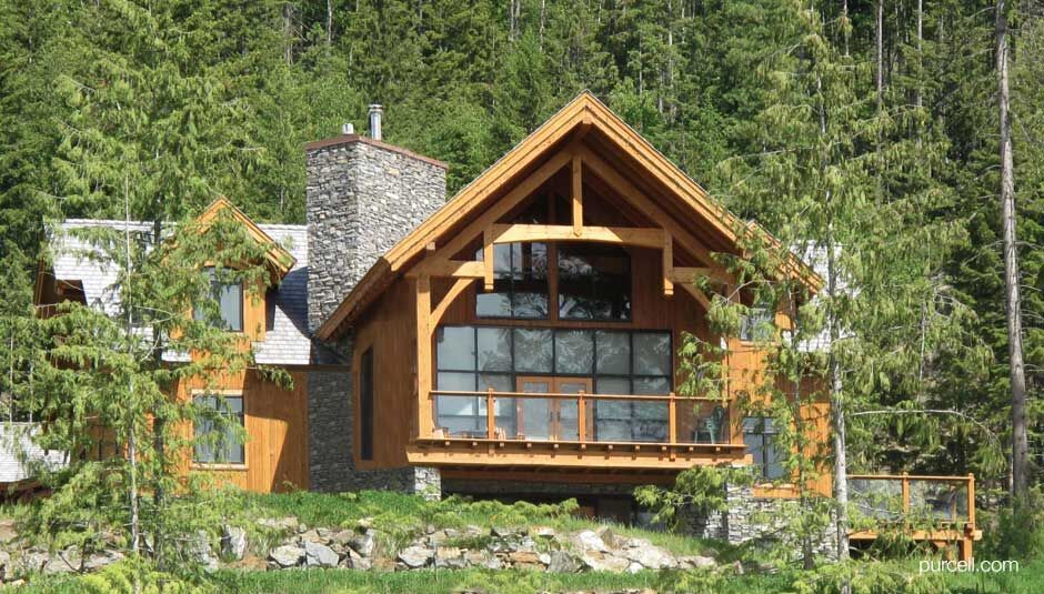 house with a combination of timber and stones surrounded by tall trees