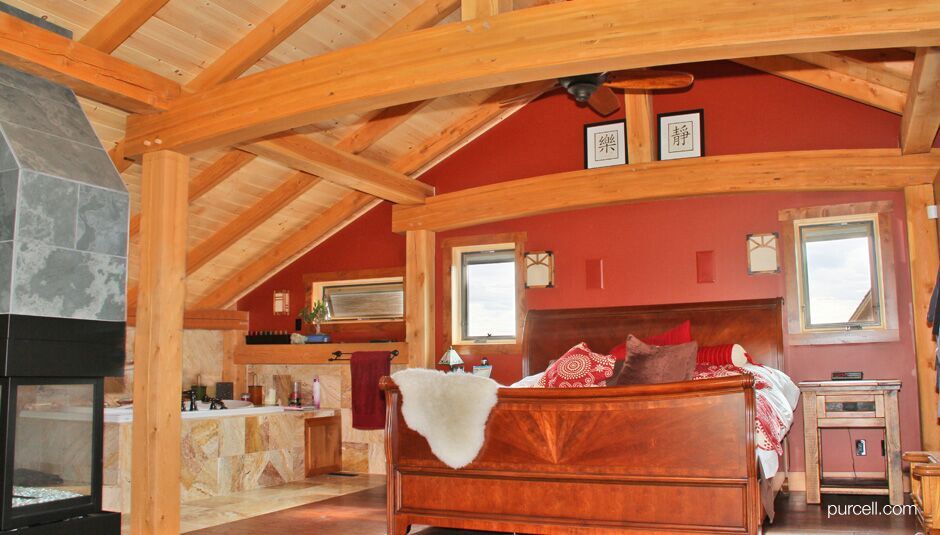 wooden bed near a bath tub with columns and ceiling made of timber