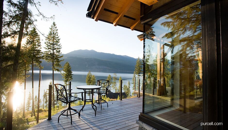 balcony with glass railings and view of a lake