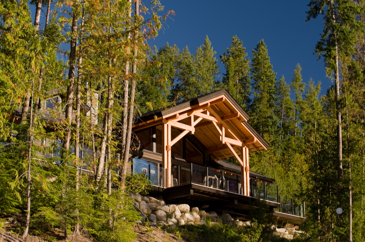 distant view of a balcony with timber roof surrounded by tall trees